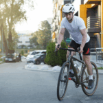 Városi kerékpáros a forgalomban, aki rendelkezik kerékpár biztosítással és megfelelő védőfelszereléssel.