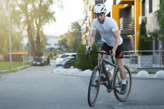 Városi kerékpáros a forgalomban, aki rendelkezik kerékpár biztosítással és megfelelő védőfelszereléssel.